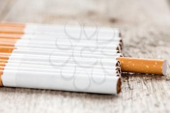 Row of cigarettes  on wooden background with selective focus