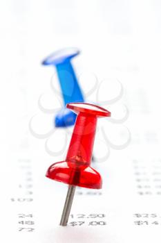 Red and blue pushpins on financial report