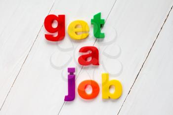 Colored letter magnets spelling text GET A JOB