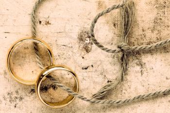 Two gold wedding rings tied with string