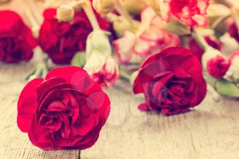  Bunch of red carnations close-up on wooden background