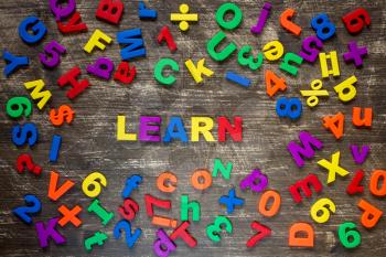 Learn written by plastic colorful letters on a wooden background
