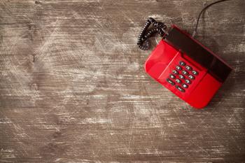 Top view of old fashioned telephone on wooden background with copy-space