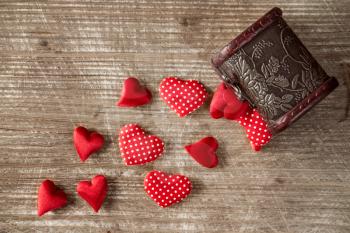 Wooden box with a pile of red hearts 