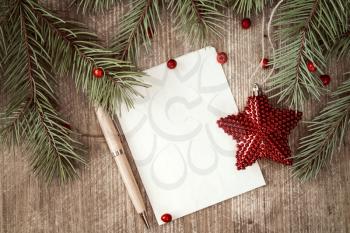 Christmas background with fir branch, red star and paper with pen for your text