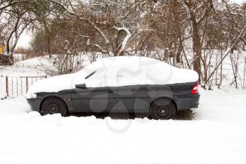 Abandoned car covered with snow in a cold weather