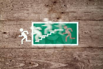 Exit sign on old wooden wall with man figure running to doorway