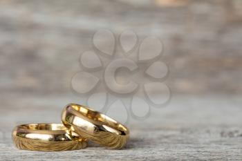 Two wedding golden rings on wooden surface