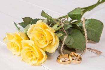 Yellow roses and wedding rings tied with string