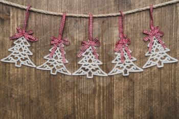 Christmas tree ornaments hanging over wooden background