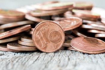 Pile of copper coins on wooden background (Euro cents)