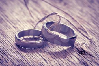 Two wedding rings tied with string, filtered image
