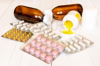 Assorted pharmaceuticals, medicine pills, tablets and capsules on wooden background