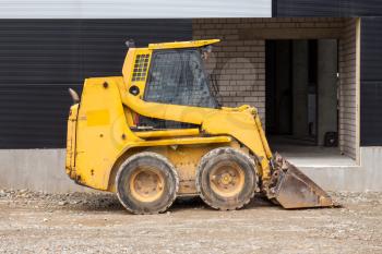 Yellow bobcat or skid loader on construction site