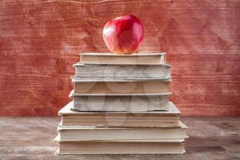 Books pyramid with red apple. Education concept.