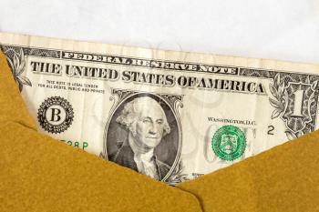 US dollar in an open brown paper envelope