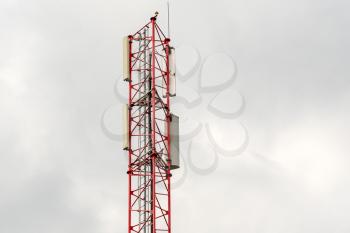 Telecommunication tower on cloudy sky background