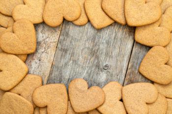 Heart shaped gingerbread cookies frame on wooden background