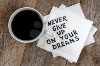 Never Give Up On Your Dreams - handwriting on a napkin with a cup of coffee