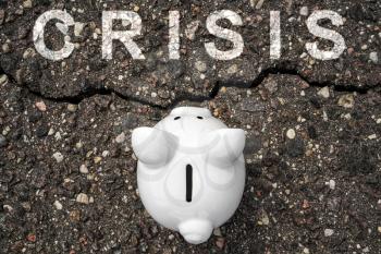 Concept financial crisis, economic depression, crash financial. Piggy bank standing near the crack in asphalt
