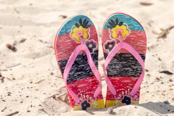Sandal flip flop on the white sand beach in summer vacations 