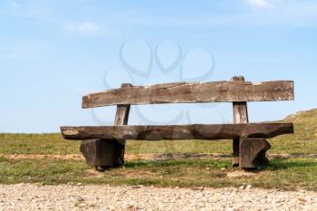 The empty wood bench in the park under blue sky