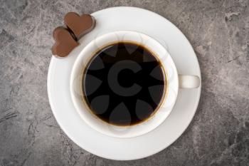 Cup of black coffee with heart shaped chocalate candies