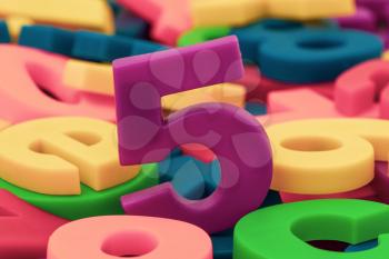 Purple number 5 on the pile of colorful plastic letters and numbers
