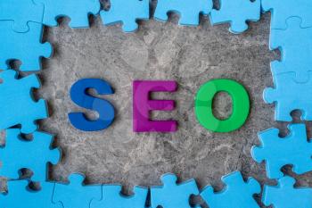 SEO, Search Engine Optimization ranking concept.Alphabets abbreviation SEO in a middle of jigsaw puzzle frame