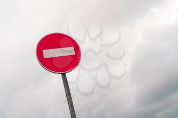 No entry sign in front of cloudy sky background