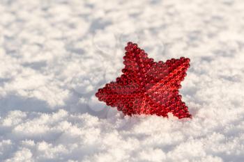 Christmas decoration red star on the fresh snow