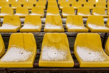 Empty Football (Soccer) Stadium Seats in the Winter Covered in Snow. Concept of Winter Sports and Game