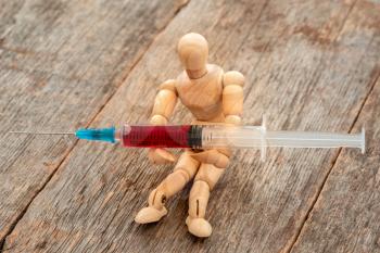 Syringe, medical injection in a doll hands. Medicine plastic vaccination equipment with needle. Liquid drug, narcotic or vaccine. 