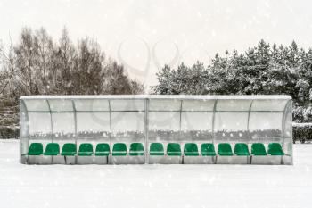 Plastic seats in a football stadium covered with snow in winter