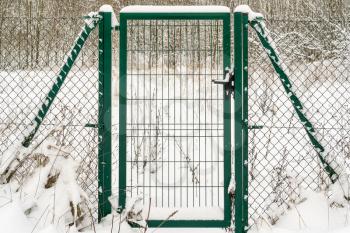 Fence with gate in wintertime covered with snow