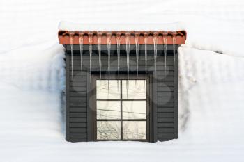 Icicles hanging from the dormer, snow covered roof