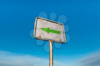 Left pointing direction sign on the blue sky background.