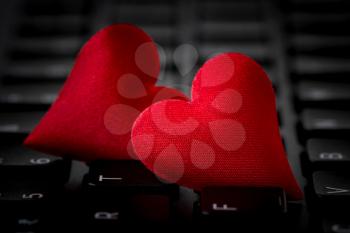 Two red hearts lie on black computer keyboard. Internet dating concept. 