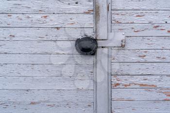 Padlock with rain protection hanging on an old wooden door 