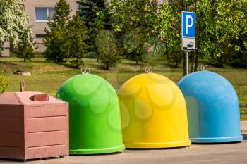 Waste separation concept. The different colored bins in the parking lot for collection of recycled materials