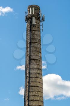 High chimney at the plant with equipment for broadcasting radio. Installing a cellular antenna. Combining the use of factory chimneys and high technology.