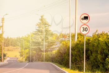 No goods vehicles  and road with speed limit 30 warning signs