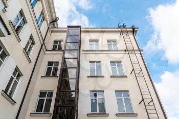 Glass elevator on a house facade. An example of living solution for persons with walking disability.