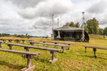 Empty rows of  wooden benches with the stage in the open air
