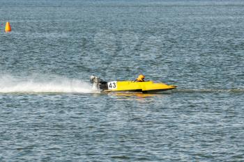 Yellow powerboat go fast along the lake in Powerboat competition