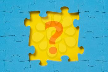Question mark in a middle of blue puzzle frame. Business concept, help concept