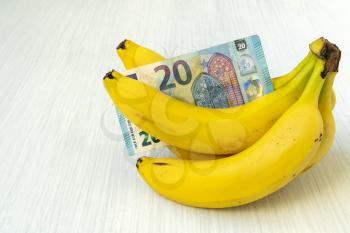 Bunch of ripe banana with Euro currency. Conceptual image.