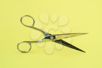 Metal scissors on yellow background. Tailor, barber concept