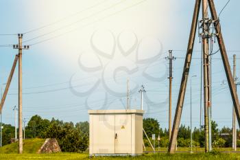 Outdoor electric high voltage cabinet surrounded by power pylons
