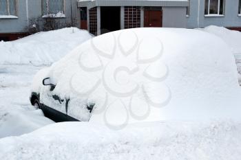 Car near the building covered by big amount of snow